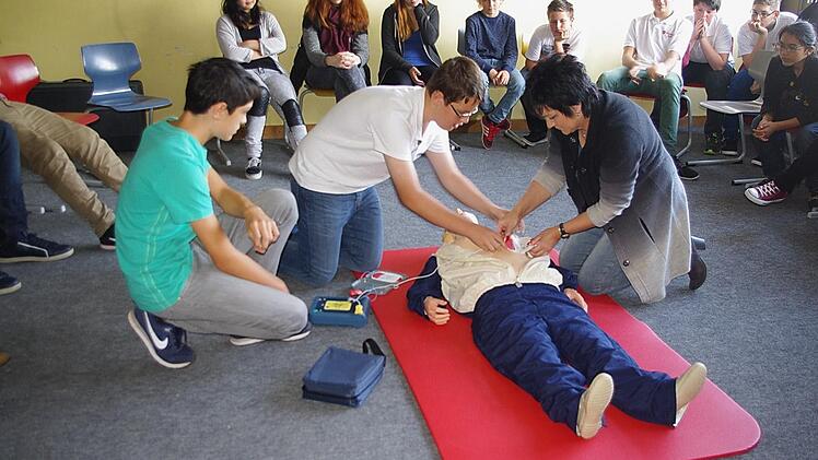 : Claudia Simon (rechts) erklärt den beiden Achtklässlern (von links) Florian und Kevin, wie ein Defibrillator eingesetzt wird.  Foto: Schülein