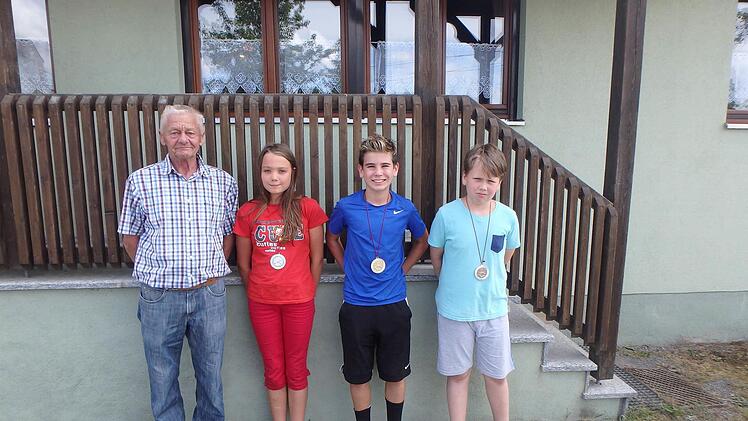 Schützenmeister Wilfried König mit den drei Besten beim Luftgewehr-Schießen (von links): Alina, Daniel und Niklas.  Foto: Anton Then