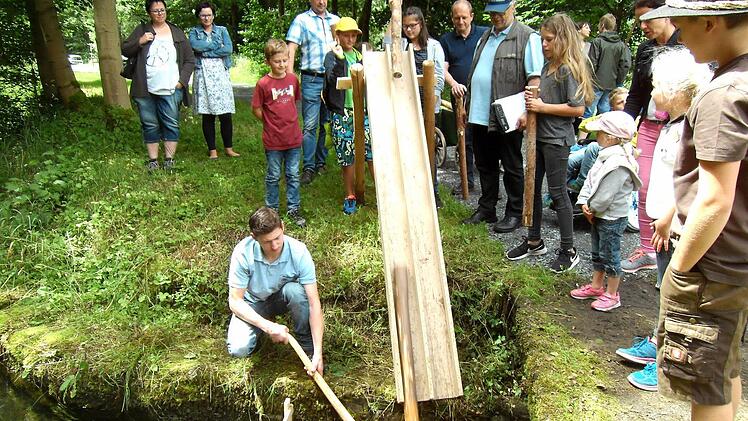 Über eine Rutsche wurde das "Blöchla" von den Kindern zu Wasser gelassen. Michael Kestel (mit Mütze) passt auf, Felix Neder (kniend) bringt die Blöchla in die richtige Position. Foto: Susanne Deuerling