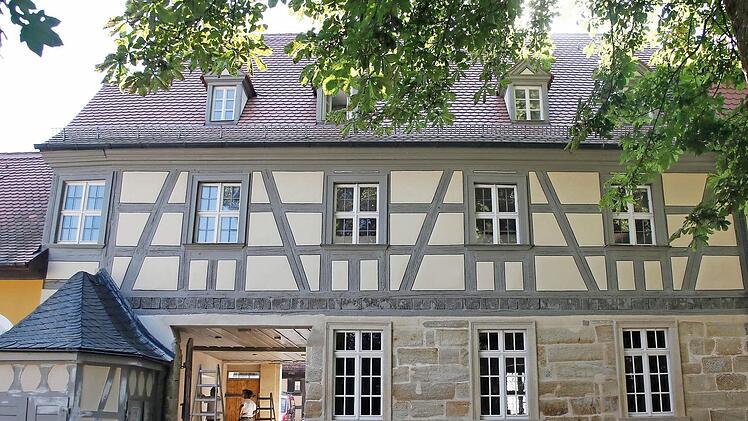Das sanierte Torhaus (Gartenansicht) mit hellem Fachwerk und rekonstruierten Gauben (links). Daneben ein Archivbild von der Straßenfront.