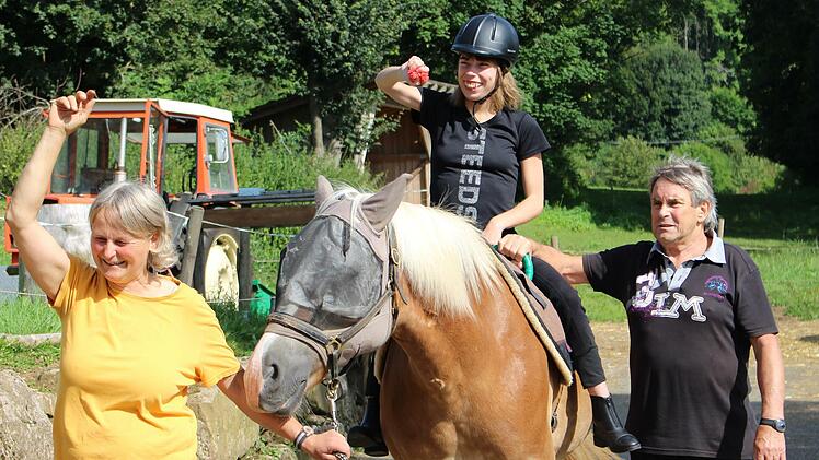 Laura Martin (auf der Stute Anni) folgt den Anweisungen von Reittherapeutin Christine Beck gerne. Lauras Vater Franz unterstützt. Foto: Julia Raab