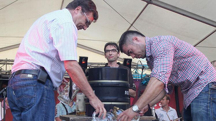 Bürgermeister Walter Ziegler (links) und Braumeister Christian Merklein beim Bieranstich, dazwischen Vorsitzender Michael Schor.