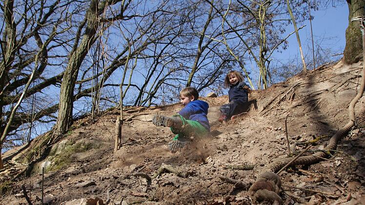 Simon (4) und Marie-Luise (5) haben Spaß beim Erdhang-Rutschen. Foto: Christian Bauriedel