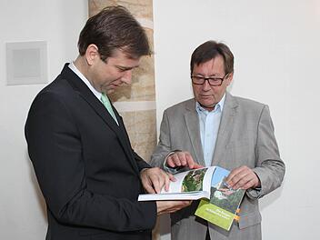 Landrat Hermann Ulm (l.) blättert als einer der ersten durch den von Toni Eckert (r.) überarbeiteten Kulturführer.  Foto: Carmen Schwind