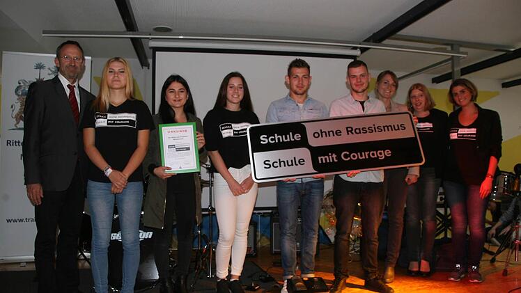 Bei der Urkundenübergabe (von rechts): die Verbindungslehrerinnen Seyran Reyhan und Eva Haber, Sabine Gerstner (Regionalbeauftragte für das Netzwerk SOR-SMC vom Bezirksjugendring Oberfranken), Markus Hönig ("Kay-A"), Andreas Martin (Eyem), Madeleine Haller, Olivia Konrad (als Vertreterinnen für zwei Schülersprecherinnen), Dilara Pistil (1. Schülersprecherin) und Schulleiter Ulrich Barth. Foto: Sylvia Hubele