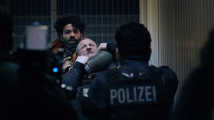 Geiselnahme aus Verzweiflung: Joon Rostami (Altamasch Noor, links) bedroht Roland Orbach (Maximilian Br&uuml;ckner) mit einer Waffe.