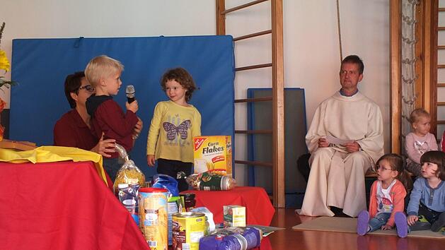 Die Kinder sammelten bei dem Gottesdienst Essen f&uuml;r die Herzogenauracher Tafel. Im Hintergrund Pastoralreferent Thomas MatzickManfred Welker