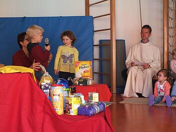 Die Kinder sammelten bei dem Gottesdienst Essen für die Herzogenauracher Tafel. Im Hintergrund Pastoralreferent Thomas MatzickManfred Welker
