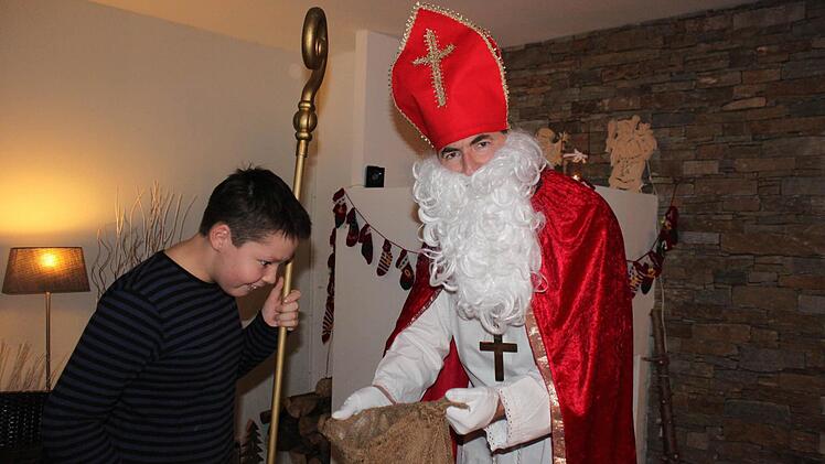 Jannis guckt neugierig in den Sack seines Papas, den Nikolaus.  Foto: Herteux