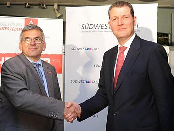 IG Metall Bezirksleiter Jörg Hofmann (li.) und der Vorsitzende der Südwestmetall Rainer Dulger geben sich  nach dem Tarifabschluss für Baden-Württemberg die Hand. Foto: Franziska Kraufmann, dpa