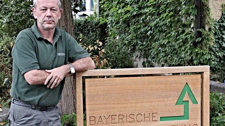 Wolfgang Gnannt am Hinweisschild zu seinem Büro in Ebern, Nikolaus-Fey-Straße, welches auf den Werkbänken der Schreinermeisterschüler entstanden ist. Foto: Helmut Will