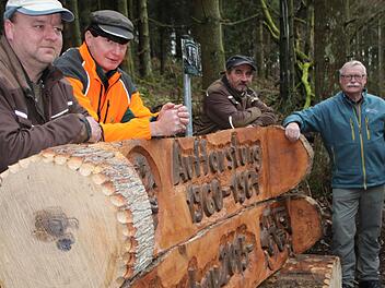 Ruhebank am Kardinal-Döpfner-Weg: Motorsägenkünstler Robert Reuscher (links) schuf eine Erinnerung an den Waldumbau. Noch auf dem Bild: Einsatzleiter Klaus Schmitt, Uwe Müller (Naturpark) und Wolfram Zeller (Leiter Forstbetrieb Bad Brückenau d. Bayer. Staatsforsten). Foto: Ulrike Müller