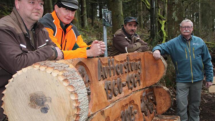 Ruhebank am Kardinal-Döpfner-Weg: Motorsägenkünstler Robert Reuscher (links) schuf eine Erinnerung an den Waldumbau. Noch auf dem Bild: Einsatzleiter Klaus Schmitt, Uwe Müller (Naturpark) und Wolfram Zeller (Leiter Forstbetrieb Bad Brückenau d. Bayer. Staatsforsten). Foto: Ulrike Müller