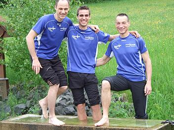 Die Freude über ihre Erfolge beim Würzburg-Marathon ist bei Marcus Enders, Alexander Eckert und Holger Trump groß. Nach dem Wettkampf müssen sie ihre heißgelaufenen Füße abkühlen, da kommt ihnen frisches Quellwasser gerade recht. Foto: Marion Eckert