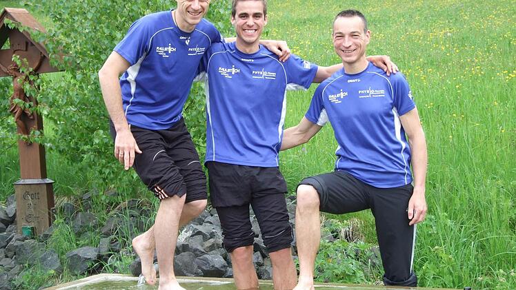Die Freude über ihre Erfolge beim Würzburg-Marathon ist bei Marcus Enders, Alexander Eckert und Holger Trump groß. Nach dem Wettkampf müssen sie ihre heißgelaufenen Füße abkühlen, da kommt ihnen frisches Quellwasser gerade recht. Foto: Marion Eckert