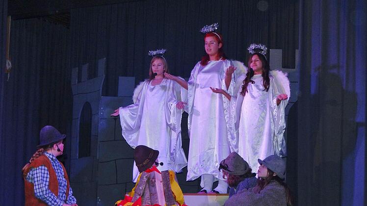 Drei Engel erscheinen während der Hirtenparty rund um das Lagerfeuer und verkünden die Geburt Jesu. Die Schauspielgruppe der Mittelschule inszeniert ein Krippenspiel nach eigener Art. Foto: Johanna Eckert