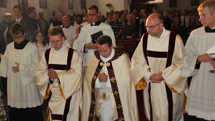 Tobias Fehn (Mitte) und andere Geistliche knien nieder zum Gebet. Foto: Veronika Schadeck