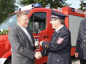 Oberbürgermeister Henry Schramm (links) überreicht den Fahrzeugschlüssel an den Kommandanten Thomas Michel; rechts Kreisbrandrat Stefan Härtlein. Foto: Sonja Adam