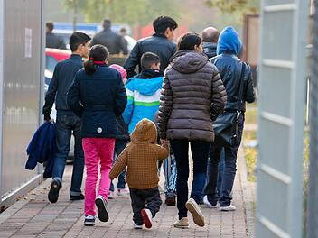 Eine Fl&uuml;chtlingsfamilie vom Balkan passiert ein Tor der R&uuml;ckf&uuml;hrungseinrichtung f&uuml;r Balkanfl&uuml;chtlinge in Bamberg.  Foto: Matthias Hoch