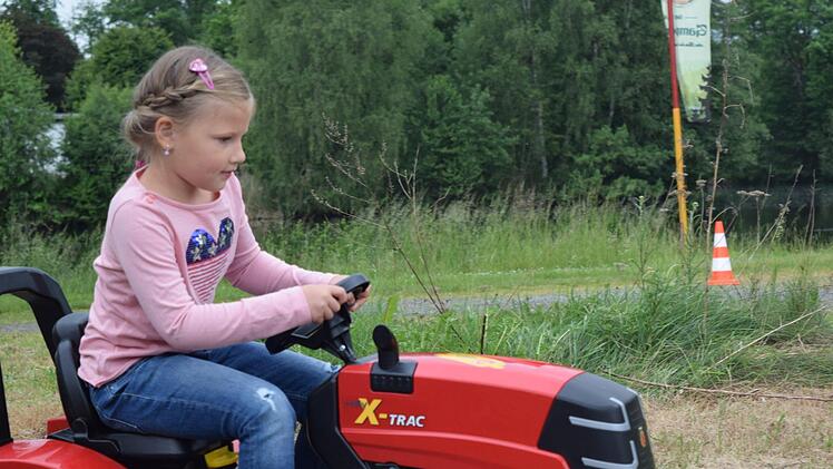 Marie, sechs Jahre alt, probiert zum ersten Mal das Fahren mit dem Traktor. Foto: Daniela Pondelicek