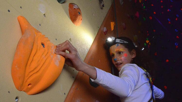 Selbst die jüngsten Kissinger Kletterer, wie hier die 11-jährige Leonie, sind mit Begeisterung beim Schwarzlichtklettern dabei. Foto: Peter Rauch