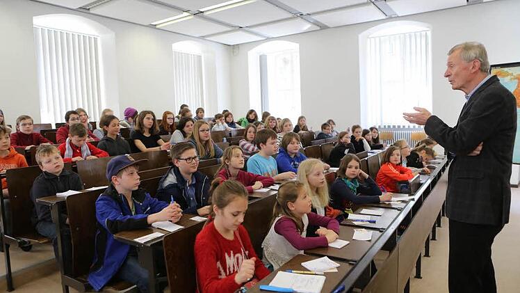 Friedrich Heckmann erklärt in seiner Kinder-Uni-Vorlesung, warum manche Menschen ihr Land verlassen und in ein anderes umziehen. Foto: Barbara Herbst
