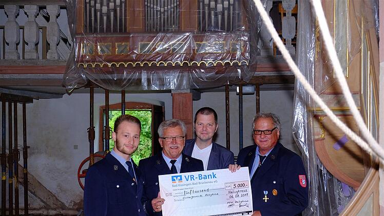 Daniel Niebusch (von links), 1. Vorsitzender der Heiligkreuzer Feuerwehr, Kassier Norbert Henning, Pfarrer Thomas Braun und 2. Vorsitzender Gerhard Dörflein bei der Spendenübergabe.  Foto: Gerd Schaar