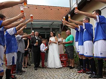Das Brautpaar mit Hochzeitsbier beim Spalierstehen der Vereine.