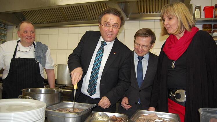 Hans-Peter Friedrich prüft schon mal, ob das Fleisch durch ist. Mit im Bild: Gastwirt Axel Fink (links), Coburgs CSU-Chefin Birgit Weber sowie Mathias Zimmer, Vorsitzender des CSU-Ortsvereins Coburg-Ost. Foto: Oliver Schmidt