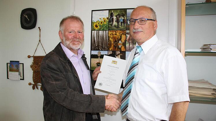 Matthias Göbhardt, Direktor des Bad Kissinger Amtsgerichts (rechts), gratuliert Reiner Simon zum Dienstjubiläum.