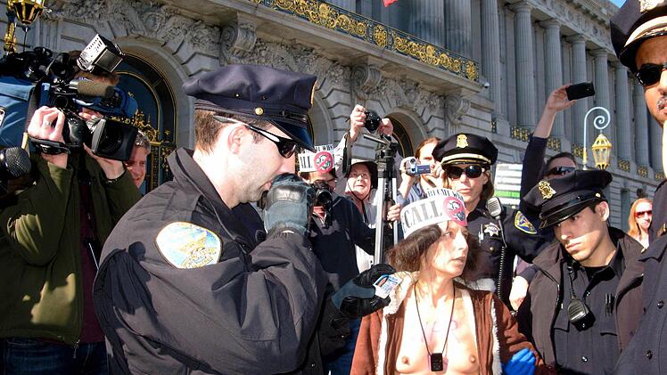 Die 43-j&auml;hrige nackte Demonstrantin Gypsy Taub steht am 01.02.2013 in San Francisco (USA) von Polizeibeamten umringt vor dem Rathaus der Stadt. Eine Handvoll Nudisten war am Freitag bei Protesten gegen ein neues Nacktheitsverbot im kalifornischen San Francisco festgenommen worden. Foto: dpa