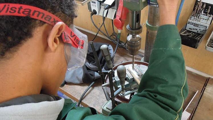 Die zehn jugendlichen Asylbewerber haben Praktika in technischen Berufen wie hier in der Zimmerei an einer Tischbohrmaschine gemacht.