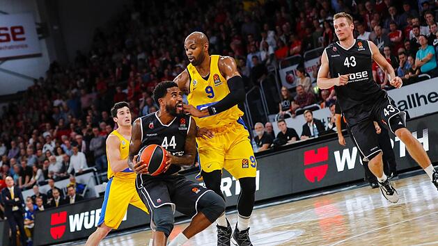 Mit einem kraftvollen Antritt l&auml;sst der Bamberger Bryce Taylor (vorn) Alex Tyrus (Maccabi Tel Aviv) stehen.