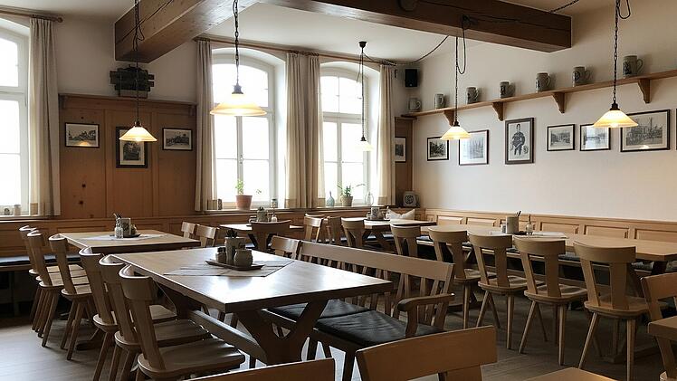 Innenansicht einer traditionellen fränkischen Gastwirtschaft mit hellen Holzstühlen und Sitzbänken für die Gäste