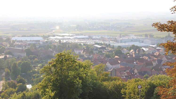 Die Fränkischen Rohrwerke, zu erkennen an den hellen Hallendächern, sind ein großes Unternehmen. Sie grenzen an die mittelalterliche Stadt an.