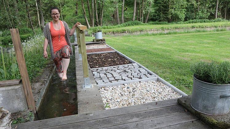 Wasser spielt in diesem Garten immer wieder eine Rolle: Katharina Fischer (links) kneippt neben dem Barfußpfad, den ihr Bruder Joschka angelegt hat. Foto: Barbara Herbst