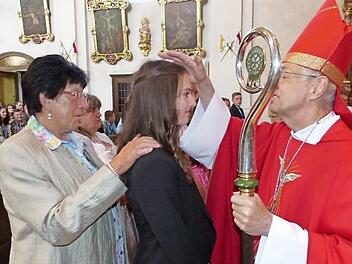 Firmling Katharina Schott (Bildmitte) mit ihrer Patin Heidi Burger (links) und dem Bamberger Erzbischof Ludwig Schick Foto: Klaus-Peter Wulf