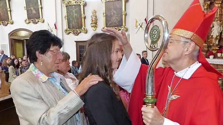 Firmling Katharina Schott (Bildmitte) mit ihrer Patin Heidi Burger (links) und dem Bamberger Erzbischof Ludwig Schick Foto: Klaus-Peter Wulf