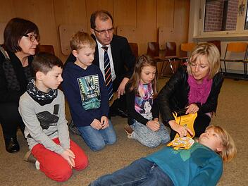 Anschaulich erklärte Konrektorin Rosi Wagner (r.) gemeinsam mit Rektorin Sieglinde Gröger (hinten l.) und VR-Geschäftsstellenleiter Wolfgang Kramer (hinten r.) den Viertklässlern Finn, Andrè und Jasmin (v. l.) sowie Paula (liegend) die Bedienung und den Nutzen des neuen schuleigenen Defibrillators. Foto: Mona Lisa Eigenfeld