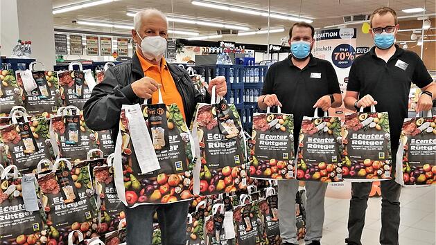Andre Pfennig (von rechts) und Benedikt Weber, stellvertretende Leiter des Edeka-Centers R&uuml;ttger, &uuml;bergeben 67 Spendent&uuml;ten an Wolfgang Speyer, Vorsitzender der Bad Kissinger Tafel.