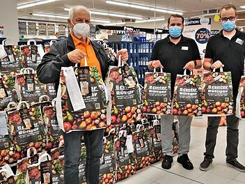 Andre Pfennig (von rechts) und Benedikt Weber, stellvertretende Leiter des Edeka-Centers Rüttger, übergeben 67 Spendentüten an Wolfgang Speyer, Vorsitzender der Bad Kissinger Tafel.