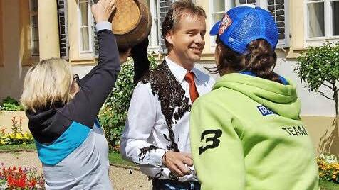 Überraschung: Touristikfachkraft Jasmin Limpert (links) begießt Kurdirektor Thomas Beck mit frischem Moor während seines Interviews mit Bayern 3-Reporterin Franziska Hainz. Foto: Sigismund von Dobschütz