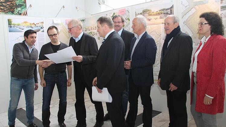 Gerd Aufmkolk überreicht den H2M-Architekten Johannes Müller und Stephan Häublein (von links) die Siegerurkunde; weiter nach rechts: OB Henry Schramm, sein Stellvertreter Stefan Schaffranek, Stadtrat Michael Pfitzner sowie Marion Resch-Heckel von der Regierung.
