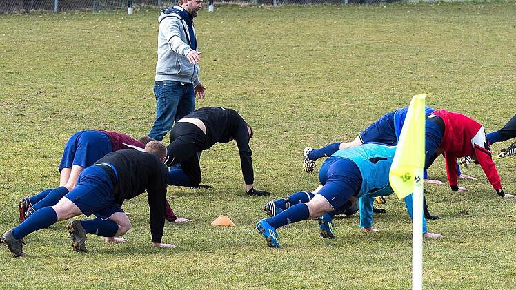 Auf allen vieren: Carsten Popp, Trainer des SV Eichenhausen/Saal, trimmt seine Spieler für das Match gegen Nordheim. Foto: Anand Anders