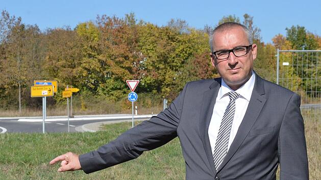 Unweit des Aschacher Kreisverkehrs (im Hintergrund) soll ein neuer Einkaufsmarkt entstehen, den die Rewe-Gruppe jetzt in der Bürgerversammlung vorstellte. Im Bild Bürgermeister Andreas Sandwall auf dem betreffenden Grundstück.  Foto: Isolde Krapf