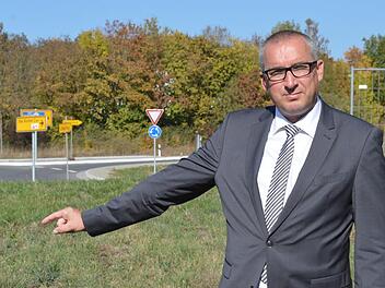 Unweit des Aschacher Kreisverkehrs (im Hintergrund) soll ein neuer Einkaufsmarkt entstehen, den die Rewe-Gruppe jetzt in der B&uuml;rgerversammlung vorstellte. Im Bild B&uuml;rgermeister Andreas Sandwall auf dem betreffenden Grundst&uuml;ck.  Foto: Isolde Krapf