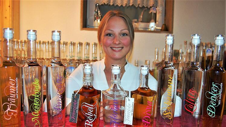 Unterm Quittenbaum: Brennerin Franziska Bischof mit Beispielen ihrer Obstbrände.  Foto: Sigismund von Dobschütz