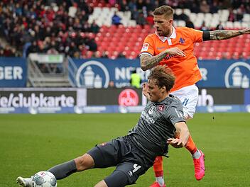 Die Protagisten des Darmst&auml;dter Ausgleichs: Der sp&auml;ter mit Rot vom Platz gestellte N&uuml;rnberger Asger S&ouml;rensen (li.) k&auml;mpft mit dem Darmst&auml;dter Tobias Kempe, der per Elfmeter das 1:1 erzielen sollte, um den Ball. Foto: Daniel Karmann/dpa