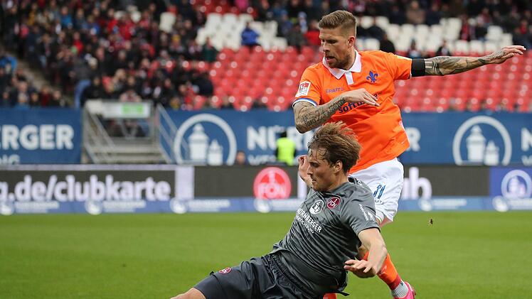 Die Protagisten des Darmstädter Ausgleichs: Der später mit Rot vom Platz gestellte Nürnberger Asger Sörensen (li.) kämpft mit dem Darmstädter Tobias Kempe, der per Elfmeter das 1:1 erzielen sollte, um den Ball. Foto: Daniel Karmann/dpa