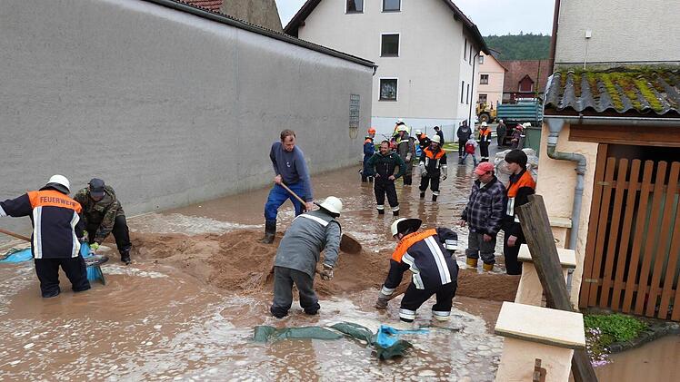 Mit einem Damm aus Sand versuchten die Helfer das Hochwasser in Wustviel (Gemeinde Rauhenebrach) einzudämmen. Fotos: Heki (3)